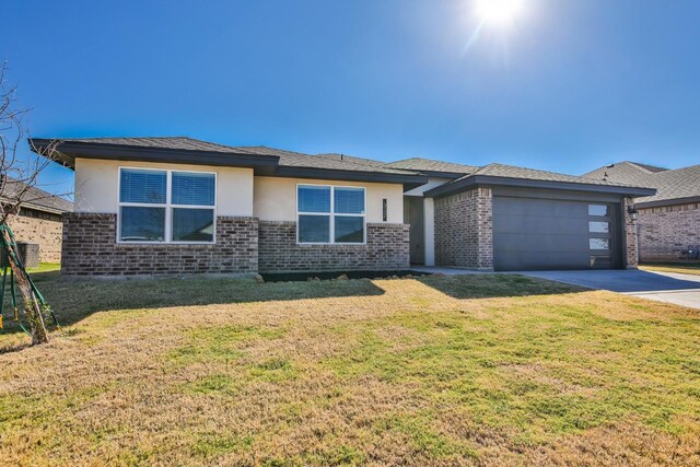 prairie-style home featuring a garage and a front yard