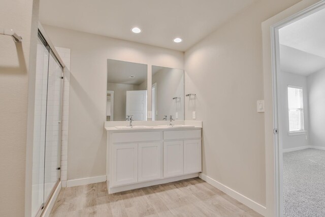 bathroom with vanity, hardwood / wood-style floors, and a shower with door