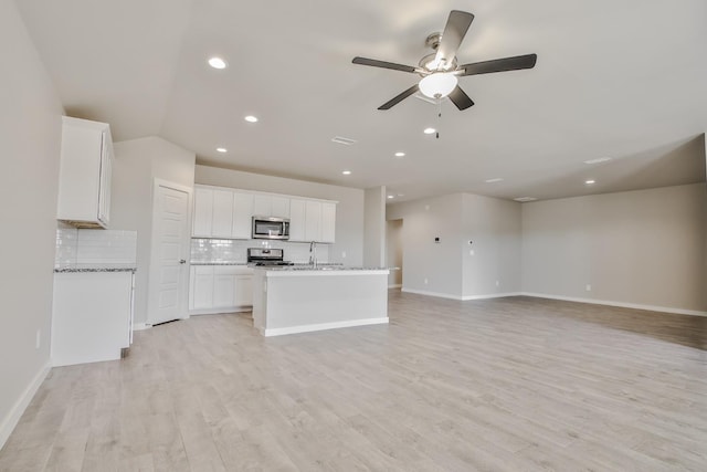 unfurnished living room featuring ceiling fan, sink, and light hardwood / wood-style floors