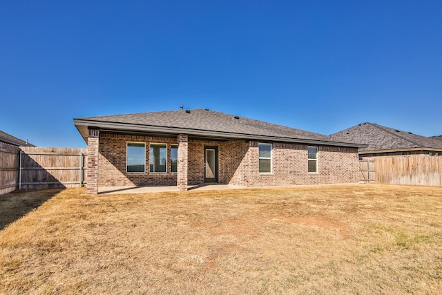 back of property featuring a patio area and a lawn