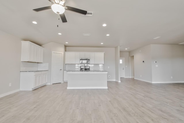 unfurnished living room with ceiling fan and light hardwood / wood-style flooring