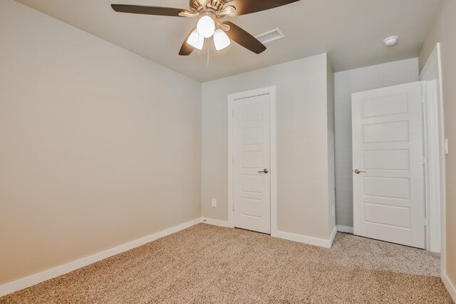 unfurnished bedroom featuring ceiling fan and light colored carpet