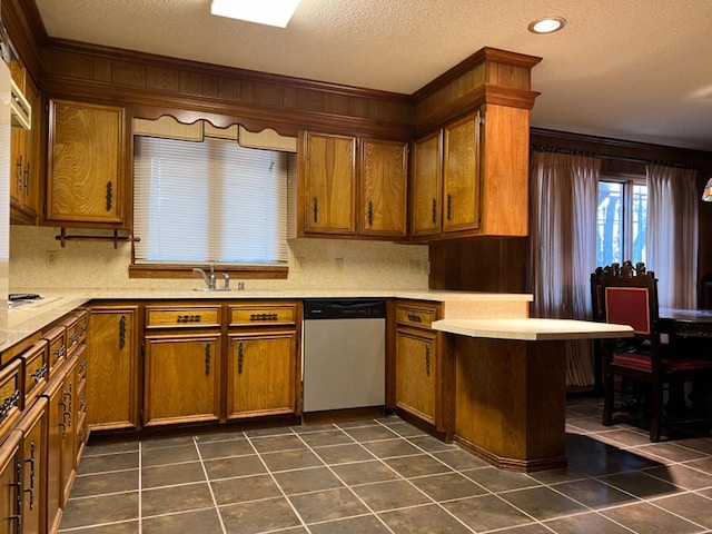 kitchen featuring dishwasher, sink, backsplash, dark tile patterned flooring, and a textured ceiling