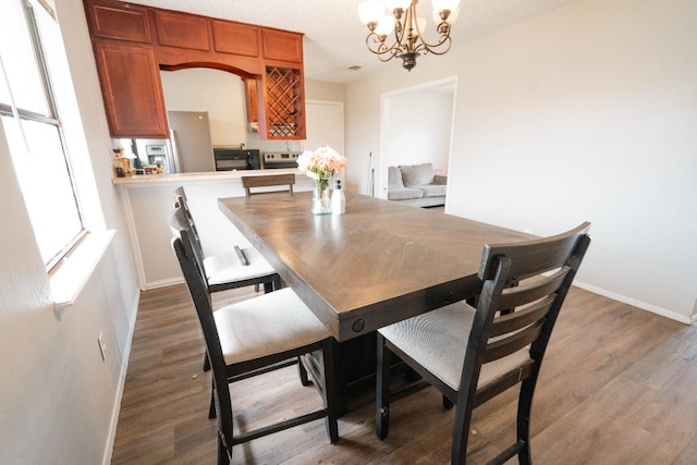 dining space with dark wood-type flooring and a chandelier