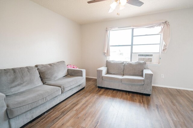 living room with cooling unit, ceiling fan, a textured ceiling, and hardwood / wood-style flooring