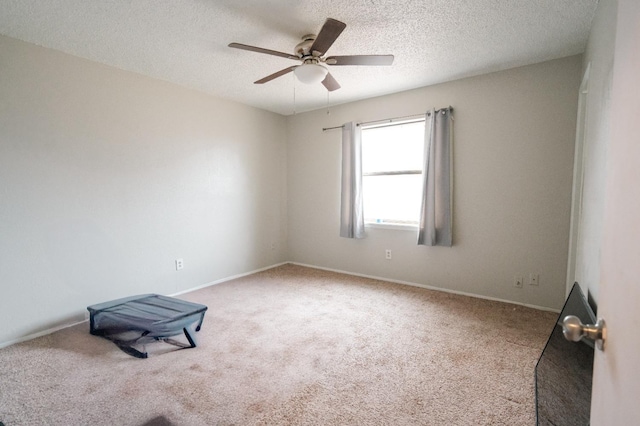 carpeted spare room with ceiling fan and a textured ceiling