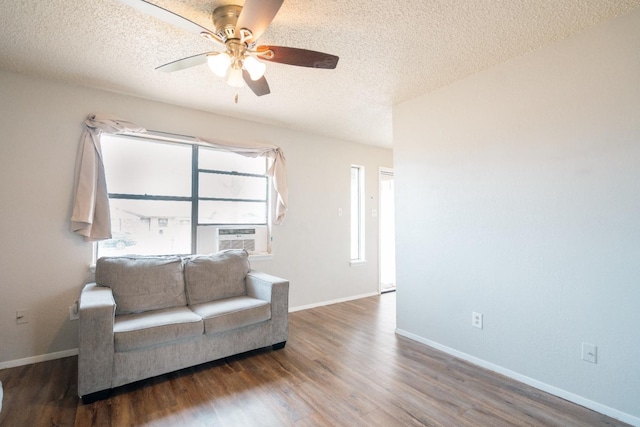 sitting room featuring dark wood-type flooring, ceiling fan, and a textured ceiling