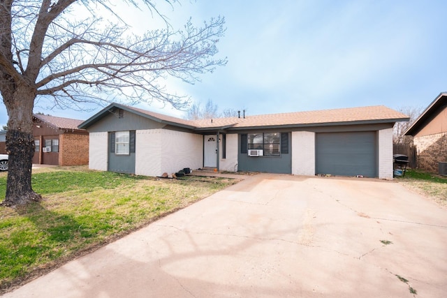 ranch-style home with a garage, central AC, a front yard, and cooling unit