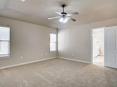 carpeted empty room featuring ceiling fan and a textured ceiling