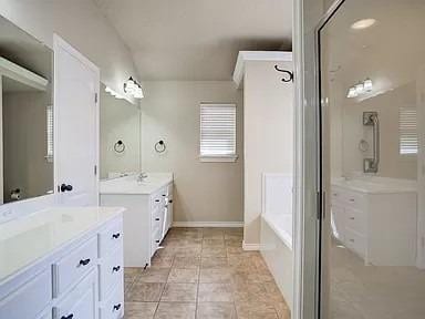 bathroom with tile patterned floors, vanity, and a bathing tub