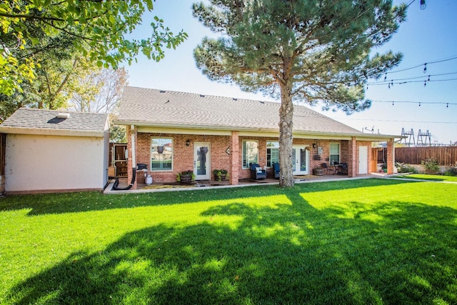 rear view of property featuring a lawn