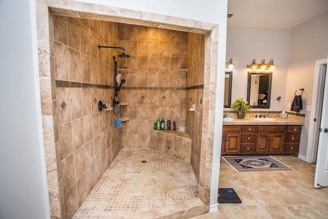 bathroom with tiled shower and vanity