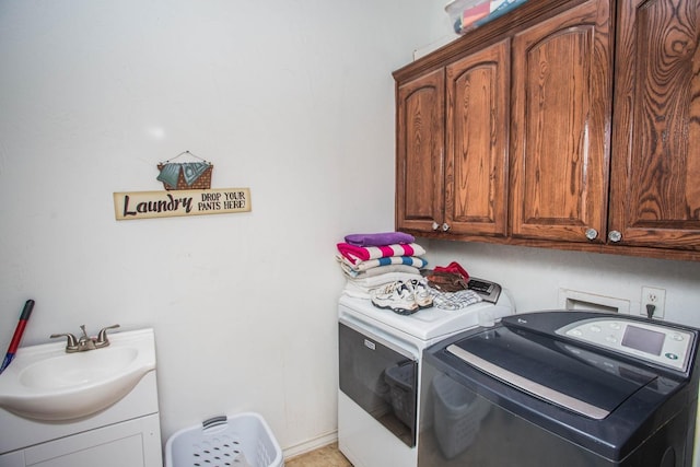 washroom with washer and dryer, sink, and cabinets