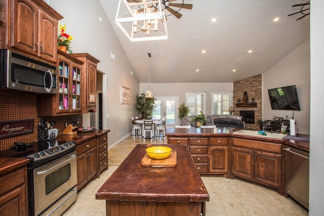 kitchen featuring sink, stainless steel appliances, a fireplace, a kitchen island, and french doors