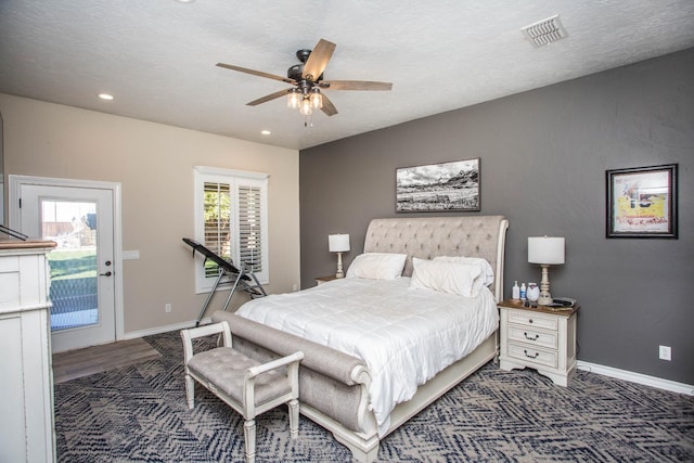 bedroom featuring ceiling fan, dark hardwood / wood-style flooring, a textured ceiling, and access to outside