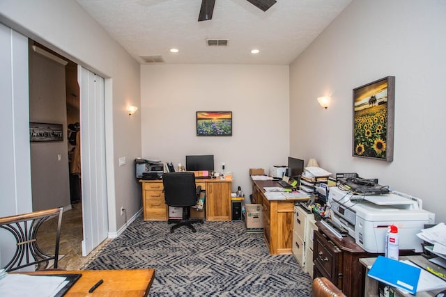 office area with ceiling fan, a textured ceiling, and dark carpet