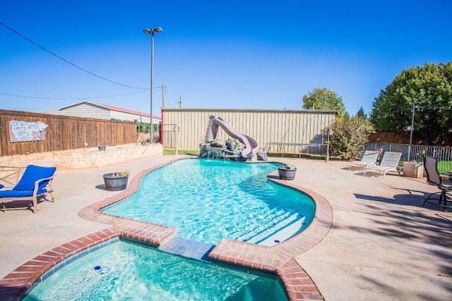 view of pool featuring a water slide and a patio area