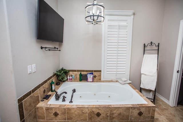 bathroom with tiled bath and a notable chandelier