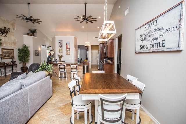 dining area featuring a barn door, high vaulted ceiling, and ceiling fan