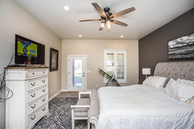 bedroom with ceiling fan, hardwood / wood-style floors, and a textured ceiling