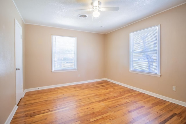 spare room featuring ceiling fan, ornamental molding, light hardwood / wood-style flooring, and a textured ceiling