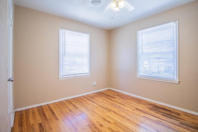 unfurnished room featuring a wealth of natural light, light hardwood / wood-style floors, and ceiling fan