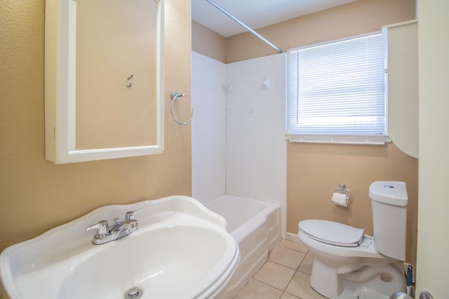 full bathroom featuring tile patterned floors, toilet, tiled shower / bath combo, and sink