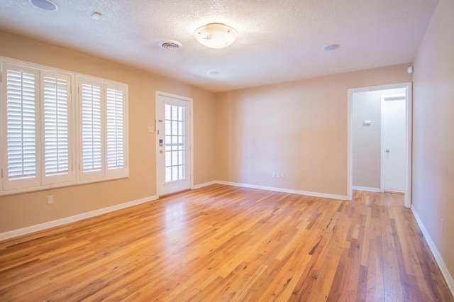 empty room featuring light hardwood / wood-style flooring and a textured ceiling