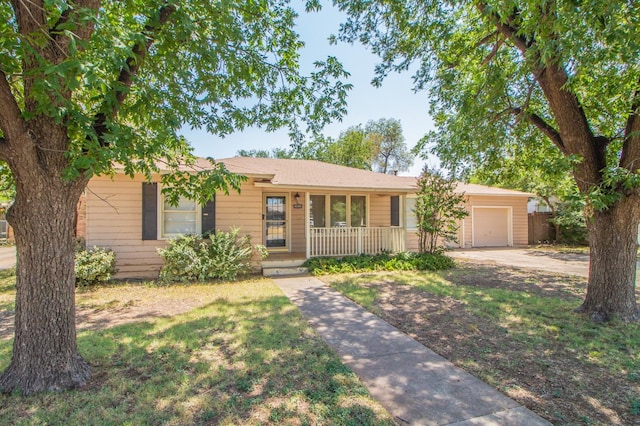 ranch-style home with a garage, covered porch, and a front lawn