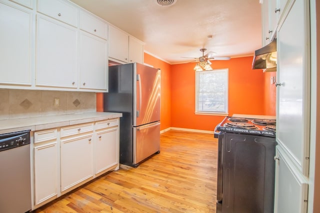 kitchen featuring ceiling fan, appliances with stainless steel finishes, tile counters, light hardwood / wood-style floors, and white cabinets