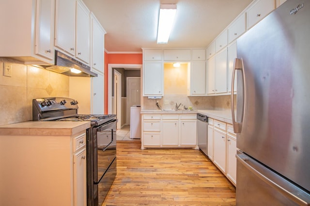 kitchen with washer / clothes dryer, sink, white cabinets, stainless steel appliances, and light wood-type flooring