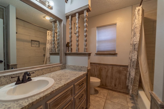 full bathroom featuring shower / tub combo with curtain, tile patterned flooring, vanity, toilet, and a textured ceiling