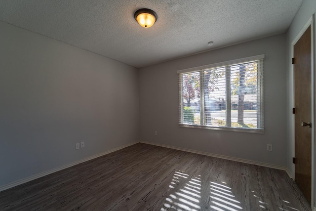 unfurnished room with dark hardwood / wood-style flooring and a textured ceiling