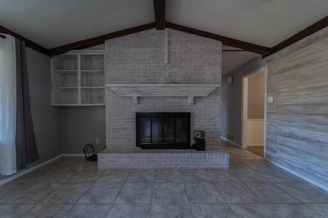 unfurnished living room featuring vaulted ceiling with beams, wood walls, a brick fireplace, and a textured ceiling