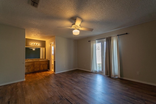 empty room featuring a textured ceiling, dark wood-type flooring, and ceiling fan