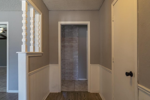 hall with dark hardwood / wood-style floors and a textured ceiling