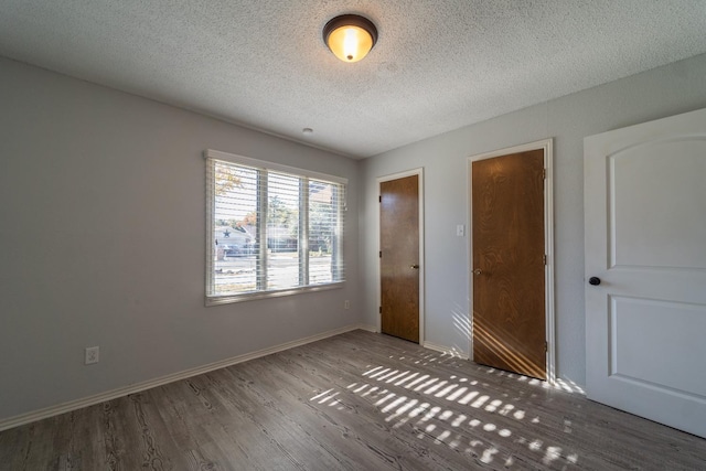 unfurnished bedroom featuring hardwood / wood-style flooring and a textured ceiling