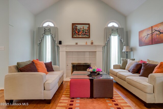 4801 Amherst St, Lubbock, TX 79416 - living area with wood finished floors, high vaulted ceiling, healthy amount of natural light, and a tile fireplace