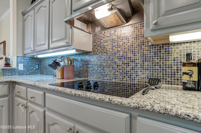 4801 Amherst St, Lubbock, TX 79416 - kitchen featuring extractor fan, tasteful backsplash, black electric cooktop, and light stone countertops