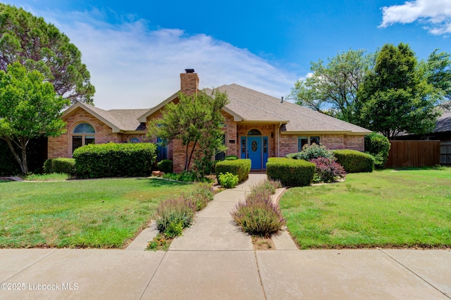 4801 Amherst St, Lubbock, TX 79416 - view of front facade with a chimney, brick siding, and roof with shingles