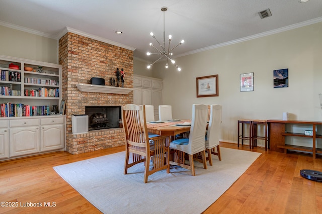 4801 Amherst St, Lubbock, TX 79416 - dining room featuring light wood finished floors, crown molding, a chandelier, and a fireplace