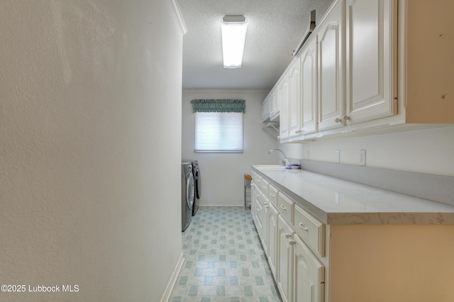 4801 Amherst St, Lubbock, TX 79416 - laundry area featuring washer and dryer, cabinet space, light flooring, and a textured ceiling