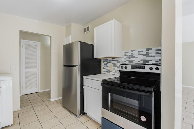 kitchen with light tile patterned flooring, washer / dryer, stainless steel appliances, decorative backsplash, and white cabinets