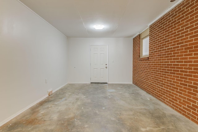 interior space with ornamental molding and brick wall