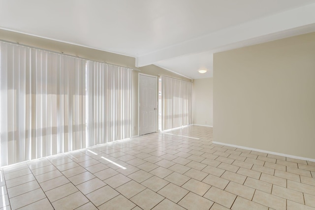 unfurnished room featuring lofted ceiling with beams