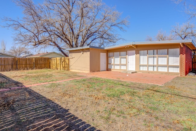 back of property with a yard and a patio