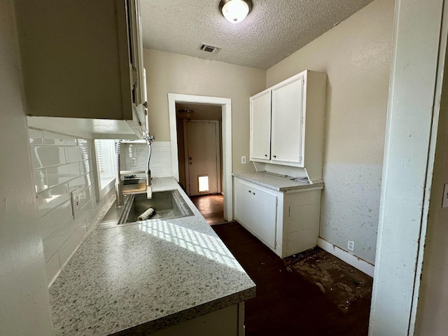 kitchen with white cabinetry and a textured ceiling