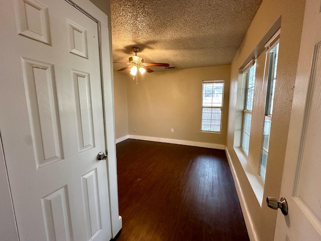 spare room featuring ceiling fan, dark hardwood / wood-style floors, and a textured ceiling