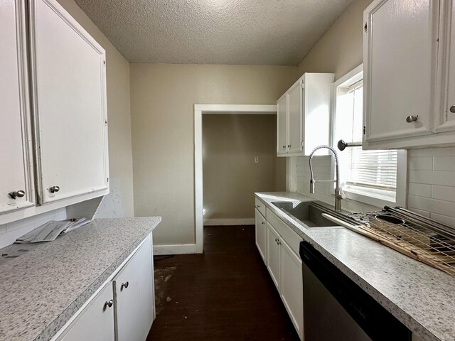 kitchen with tasteful backsplash, stainless steel dishwasher, sink, and white cabinets