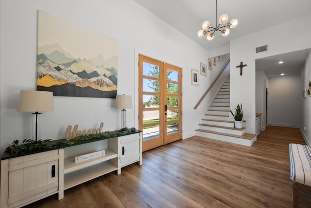 foyer entrance featuring an inviting chandelier, dark hardwood / wood-style flooring, and french doors